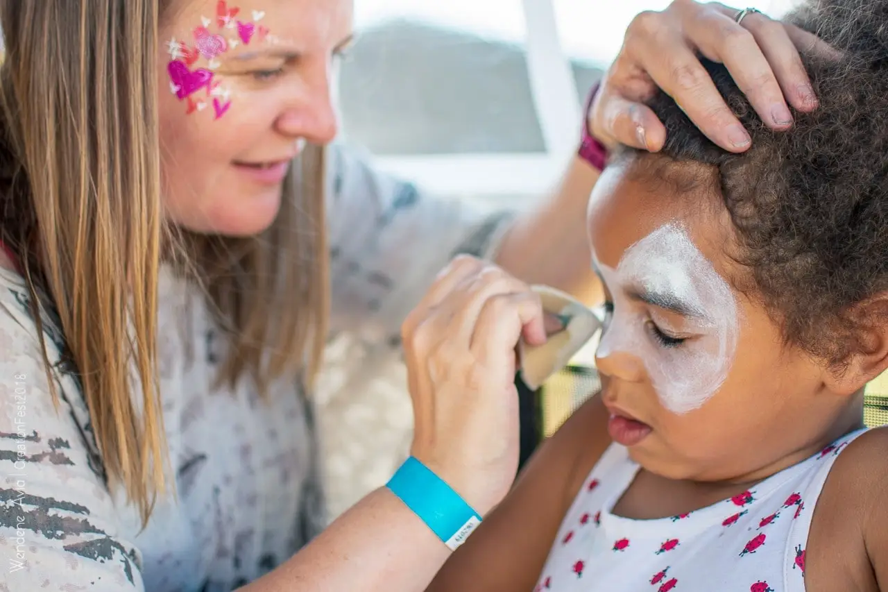 Christine painting a child's face at an event